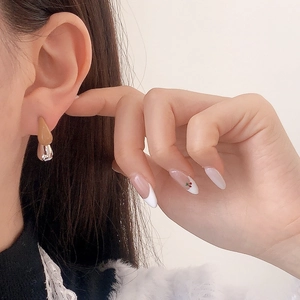 Minimalist bicolor droplet earrings in khaki and silver finish on a female model