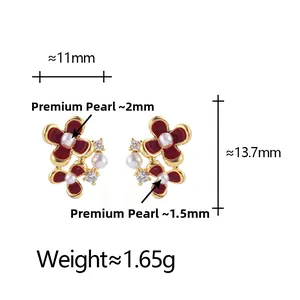 Détails des boucles d'oreilles fleurs avec pétales rouges, perles et dorures