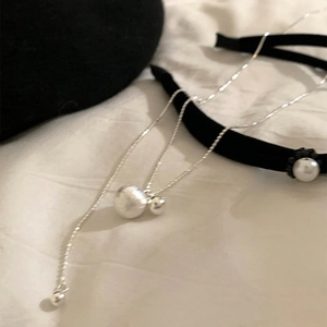 Adjustable silver long necklace with matte and polished dual beads on white fabric