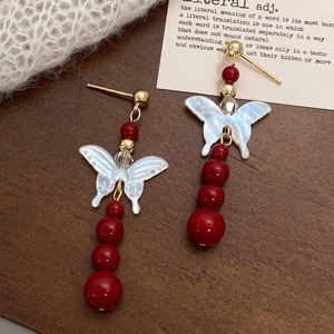 Red bead and mother of pearl butterfly drop earrings with golden metal accents