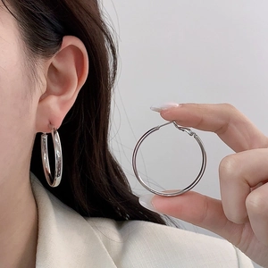 Grandi orecchini a cerchio minimalisti in argento lucido per un look quotidiano