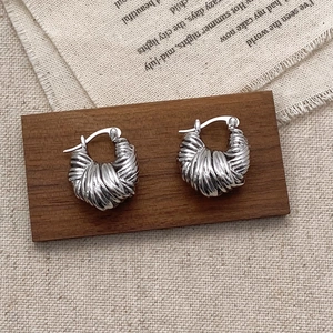 Close-up of vintage silver twisted hoop earrings with layered spiral rope texture