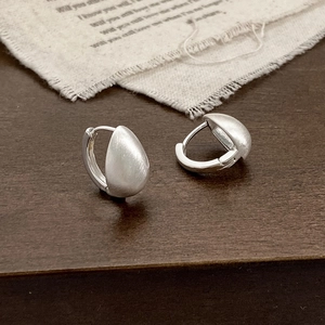 Détail de boucles d'oreilles goutte argent mat montrant la texture brossée et le fermoir