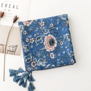Detailed view of dark blue floral cotton linen shawl with intricate fringe tassels