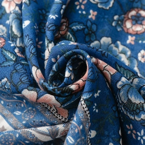 Close-up of blue floral cotton linen fabric showing intricate weave and retro print