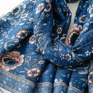 Close-up of blue ethnic scarf with detailed floral patterns and soft linen texture
