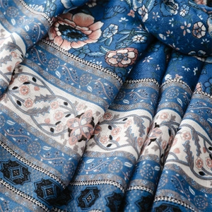 Macro detail of bohemian blue floral shawl showing soft cotton linen texture and drape