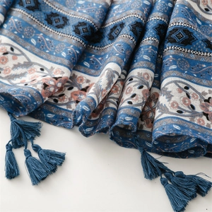 Detailed close-up of blue floral cotton linen shawl with intricate handmade tassels