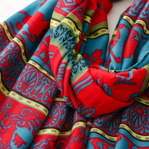 Detail of bohemian ethnic totem print scarf in vibrant red and blue cotton feel fabric
