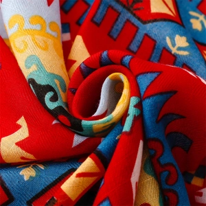 Détail macro du châle bohème rouge aux motifs ethniques géométriques et texture coton-lin