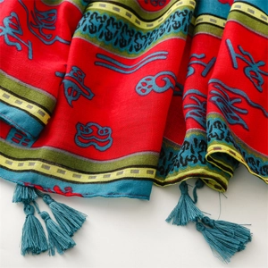 Detailed macro view of ethnic red cotton linen scarf with blue tassels and folk patterns
