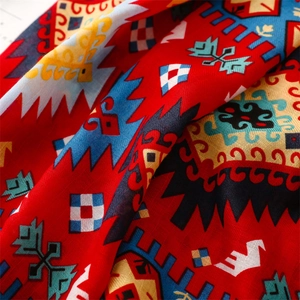 Gros plan d'une écharpe bohème rouge avec motifs géométriques et texture lin