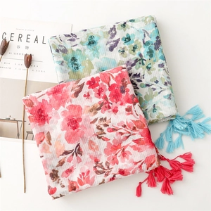Macro detail of watercolor floral scarf with fringe and soft linen texture
