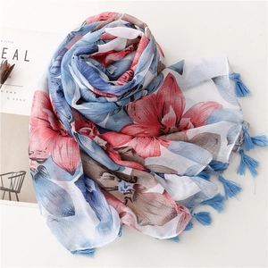 Détail de l'écharpe en coton et lin à fleurs avec des glands de couleur turquoise