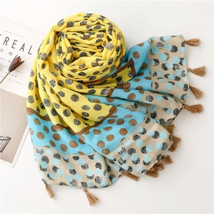 Detailed view of color block scarf with polka dots and bohemian fringe decoration