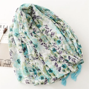 Detail of floral linen-feel scarf with blue tassels and textured vertical stripes