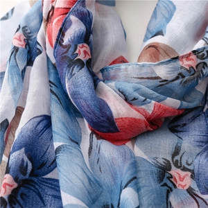 Détail macro d'une écharpe légère en coton et lin avec imprimés floraux et coutures soignées