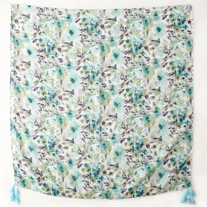 Detail of floral printed scarf with breathable fabric texture and blue silk tassels