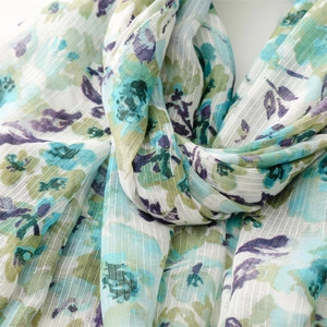 Detail of thin linen-feel scarf with fresh watercolor flower print and soft fringe