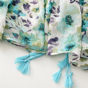 Detail of floral linen-feel scarf with blue tassels and textured vertical weave