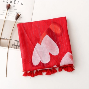 Detail of red scarf with heart patterns, silver thread stripes and tassel fringe