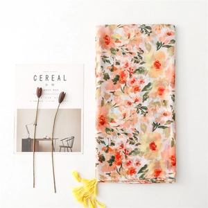 Detail of floral linen-feel scarf with fringe edges next to a cereal magazine