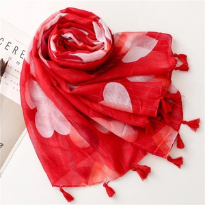 Detail of red scarf featuring white heart patterns and silver metallic silk stripes