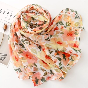 Detail of floral linen-feel scarf with tassels and artistic flower print texture