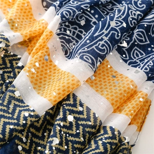 Detailed macro view of lightweight scarf featuring navy paisley and silver foil patterns