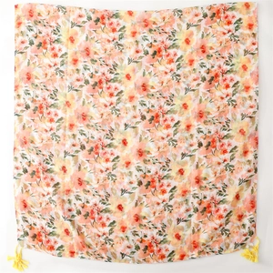 Detail of warm orange floral cotton-linen scarf featuring delicate corner tassels