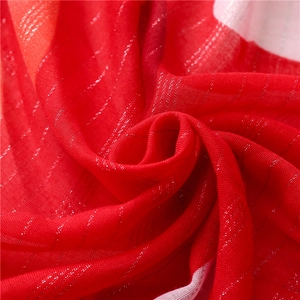 Close-up of red textile fabric with woven silver metallic threads and soft texture