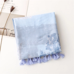 Detail view of light blue printed scarf with elegant fringes on minimalist white background