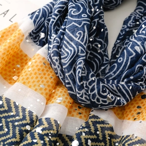 Close-up of bohemian silk scarf with gold foil accents and ethnic geometric patterns