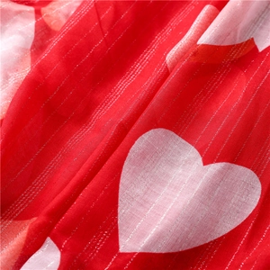 Detailed view of red heart print fabric with silver silk stripes and soft texture