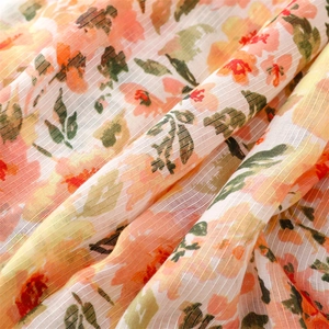 Close-up of floral print cotton linen scarf fabric with slub yarn texture and tassels