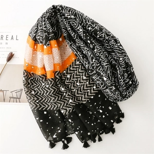 Detail of scarf with orange stripes, ethnic prints, and silver foil accents with tassels