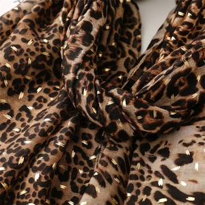 Gros plan détaillé du foulard léopard avec points dorés et tissu léger respirant