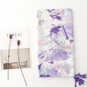 Detail of purple floral scarf with fringe tassels and soft cotton-linen texture
