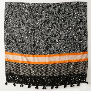 Detail of paisley pattern shawl with orange stripes and black fringe tassels