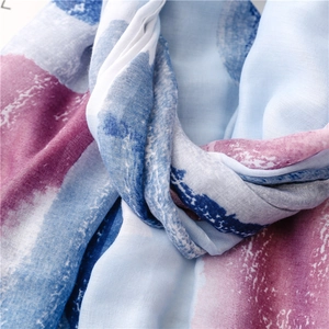 Close-up of soft cotton-linen shawl featuring blue and burgundy gradient watercolor patterns