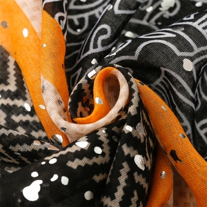 Macro shot of lightweight scarf featuring orange and black geometric tribal patterns