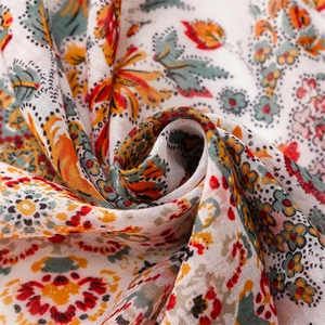 Détail macro du foulard bohème montrant la texture douce en coton-lin et les motifs