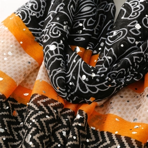 Detail of paisley patterns and silver foil accents on a lightweight chic scarf