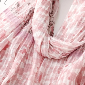 Close-up of pink floral and checkered scarf showing delicate cotton linen texture