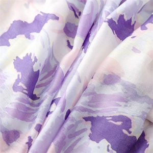Detailed close-up of soft ink-wash floral print fabric with purple and pink pastel tones
