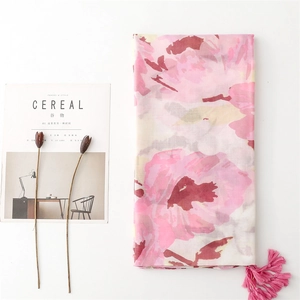 Detail of pink floral printed shawl with delicate fringe tassels on soft white cotton fabric