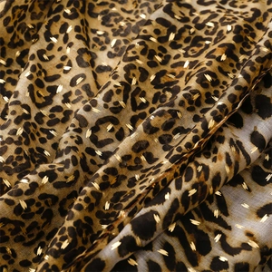 Détail du tissu léopard avec points dorés montrant la texture douce et le drapé