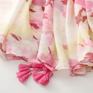 Detailed view of floral print shawl with soft texture and bright pink fringe tassels
