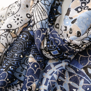 Detailed close-up of blue butterfly pattern scarf with elegant gold foil accents