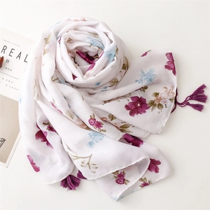 Detailed close-up of a floral cotton linen scarf with purple flowers and silk tassels